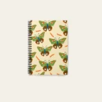 Spiral notebook with whimsical butterfly illustration, featuring artist-designed cover and compact size.