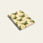 Spiral notebook with whimsical butterfly illustration, featuring artist-designed cover and compact size.