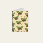 Spiral notebook with whimsical butterfly illustration, featuring artist-designed cover and compact size.